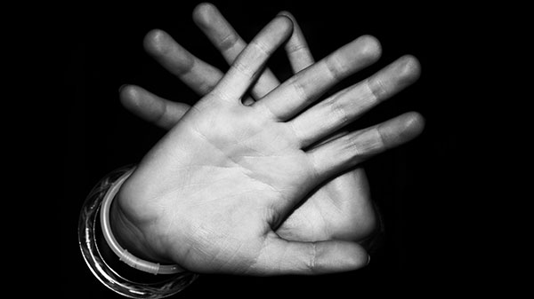 Photo of hands held up in "stop" gesture