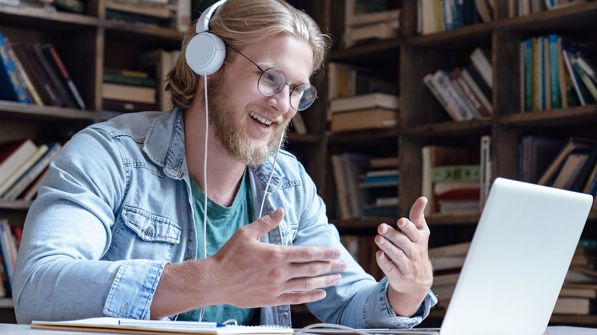 Young man gesturing at a laptop