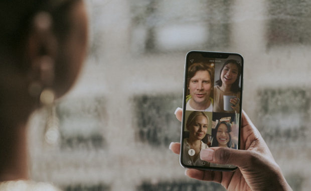 Photo of a woman attenging a remote meeting on her phone for an article on how to succeed at remote networking