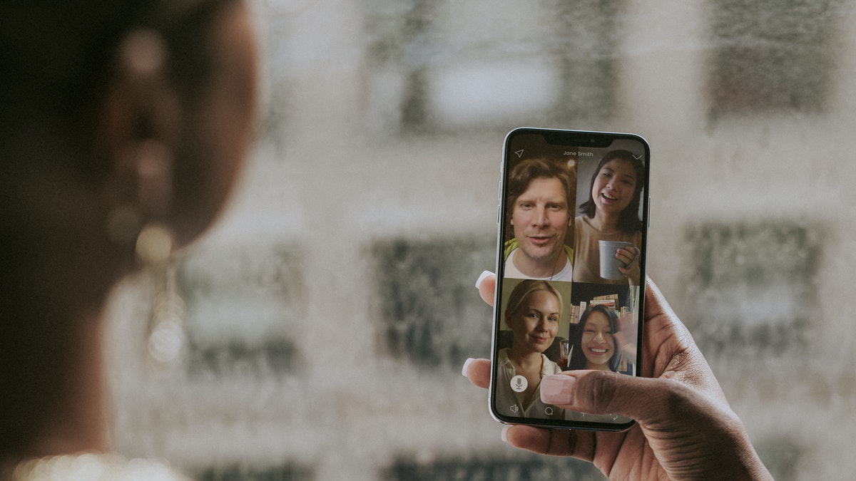 Photo of a woman attenging a remote meeting on her phone for an article on how to succeed at remote networking